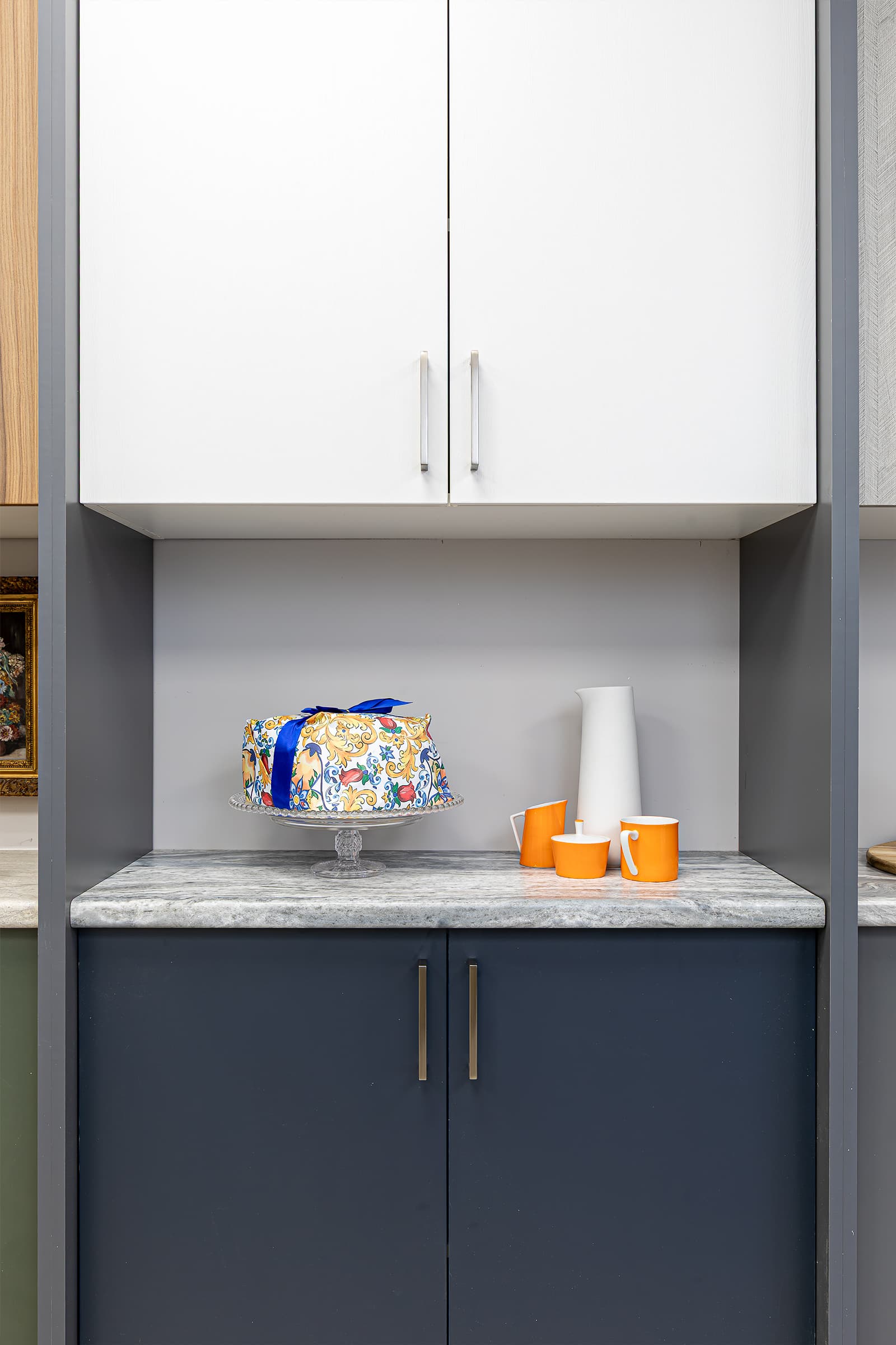 cabinet door and countertop display white vase, orange coffee cups