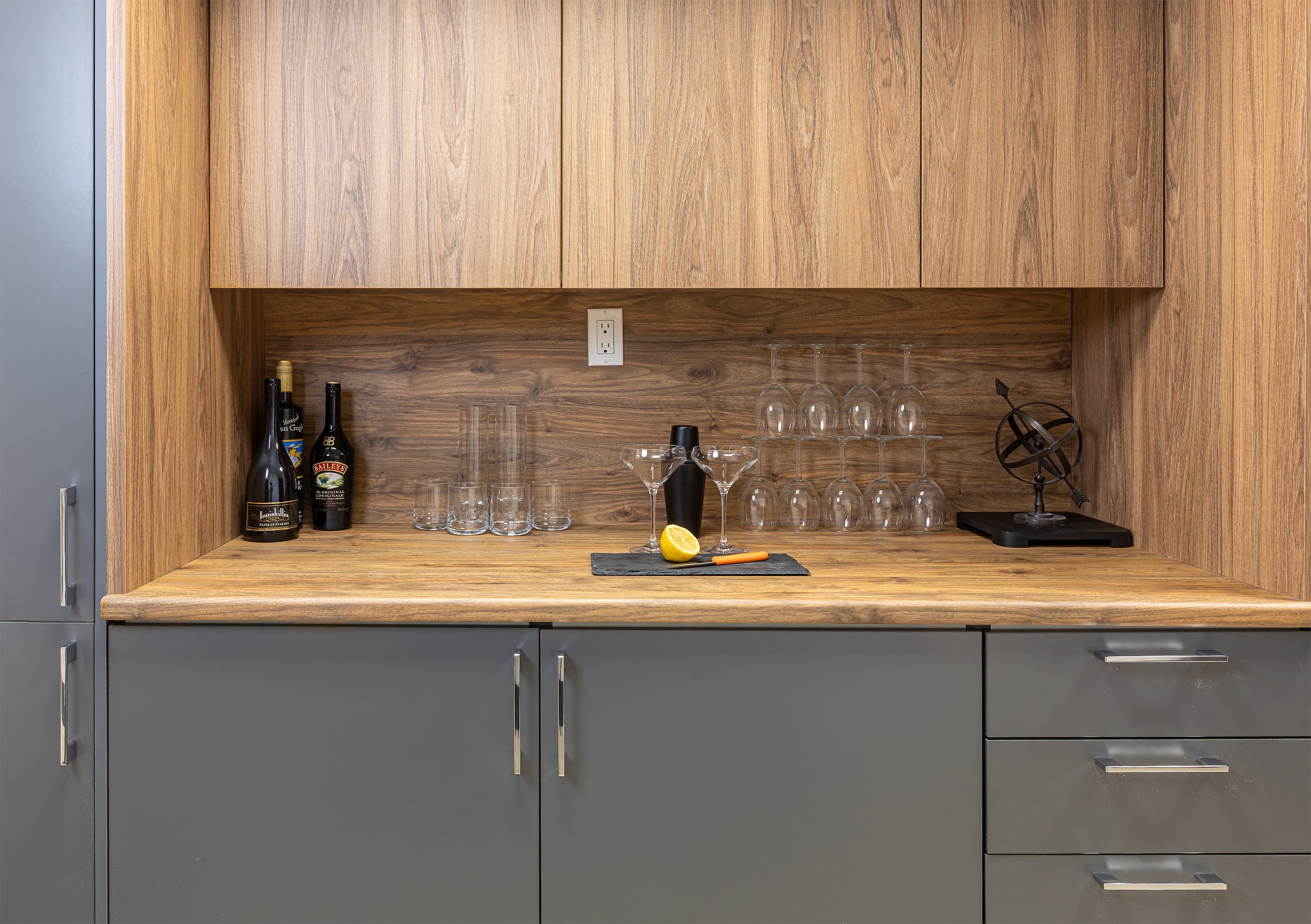 wide shot of grey and walnut cabinetry with bar