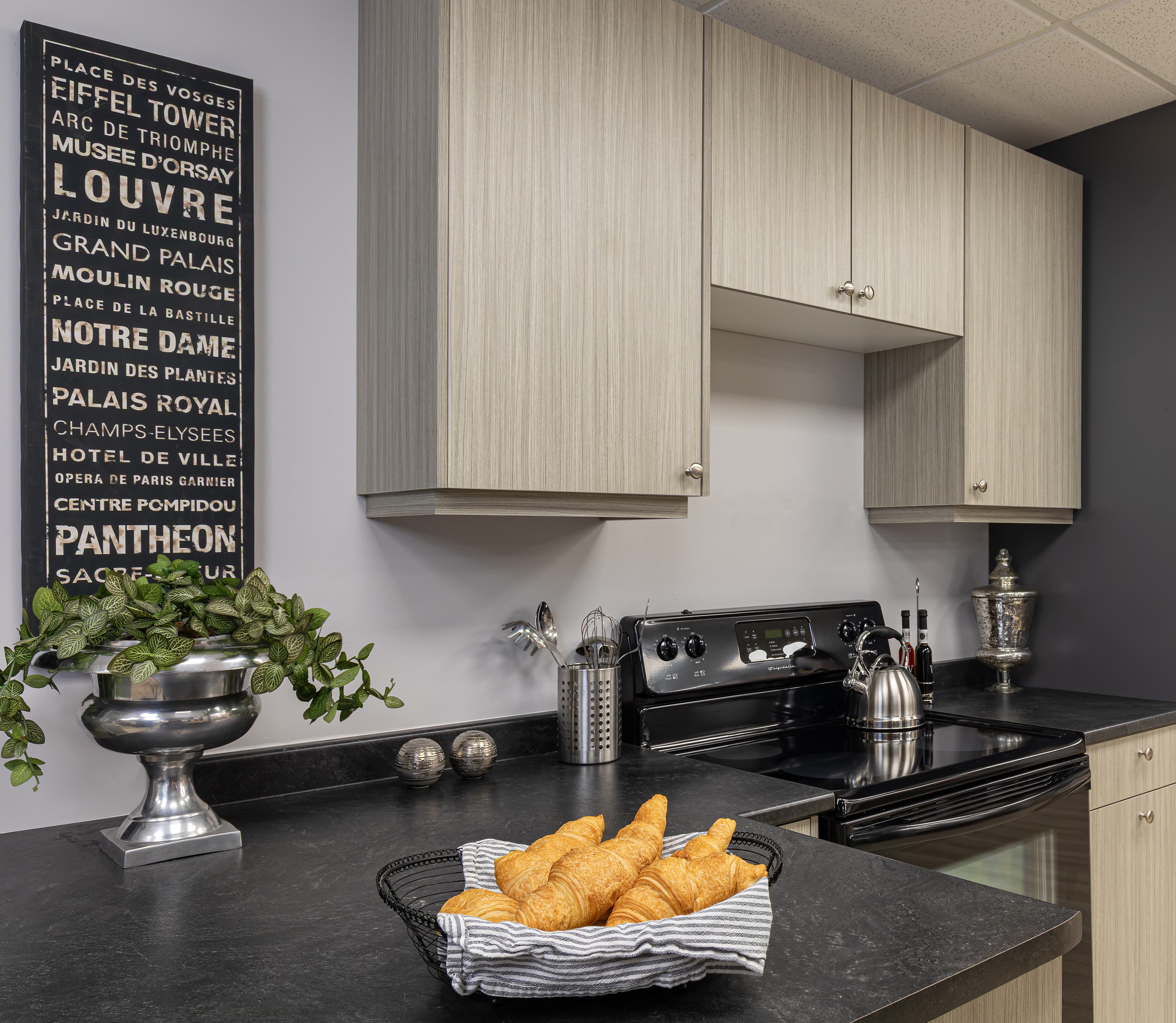 wide shot of kitchen with dark countertop and croissants