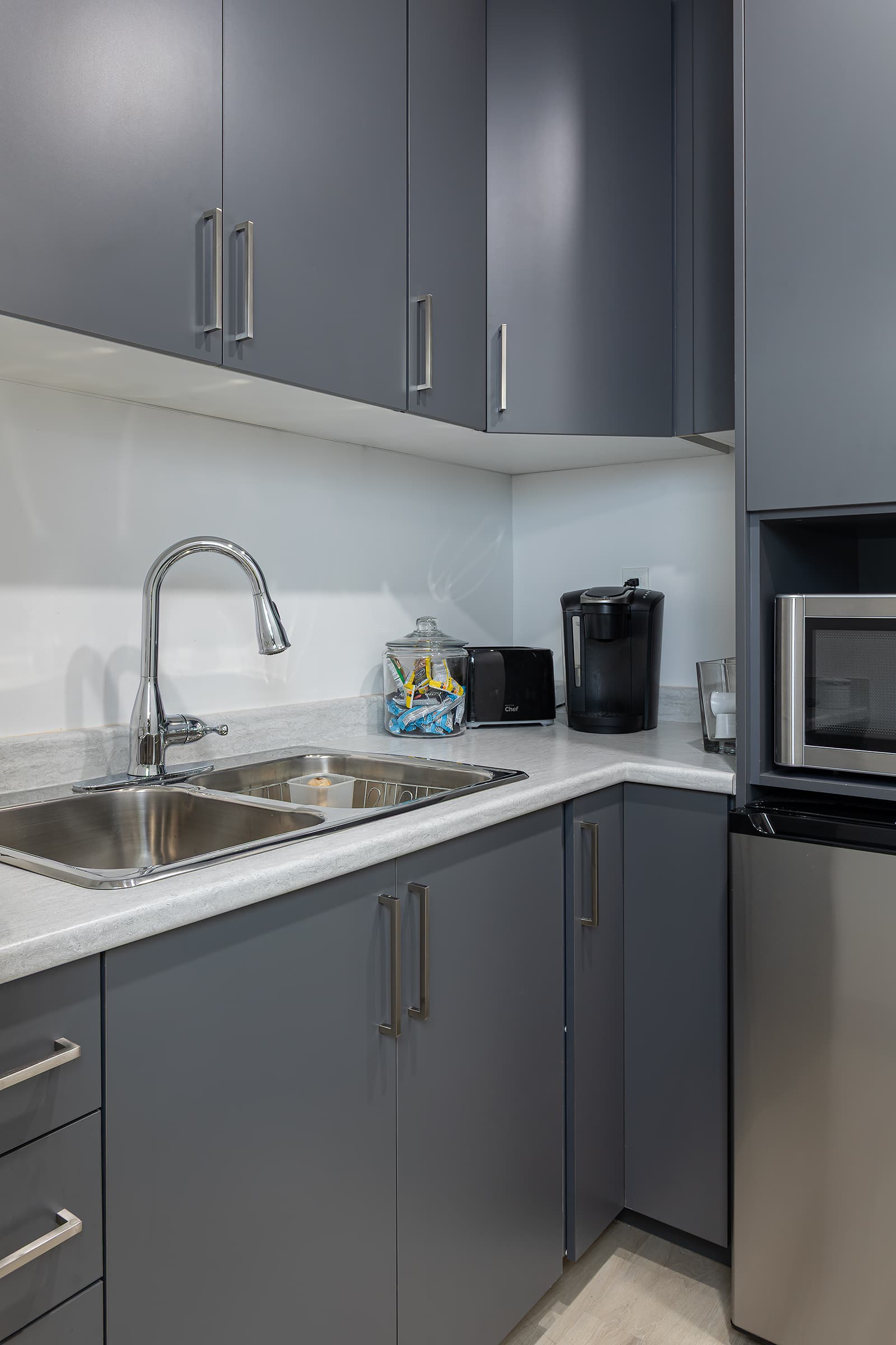 staff kitchen with gray cabinetry and sink